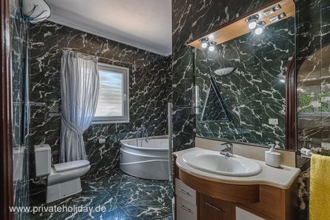 Bathroom with corner bathtub and stone-look walls – El Tanque, Tenerife