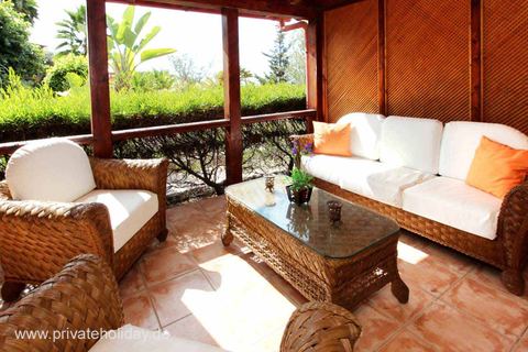Terraza cubierta con sofá de ratán y vistas al jardín – Chio, Tenerife