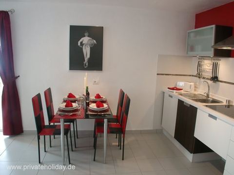 Mesa de comedor con cuatro sillas y cocina abierta – Chio, Tenerife
