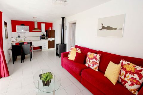 Sala de estar con sofá rojo y cocina abierta – Chio, Tenerife