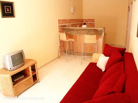Living area with red sofa and breakfast bar – Chio, Tenerife