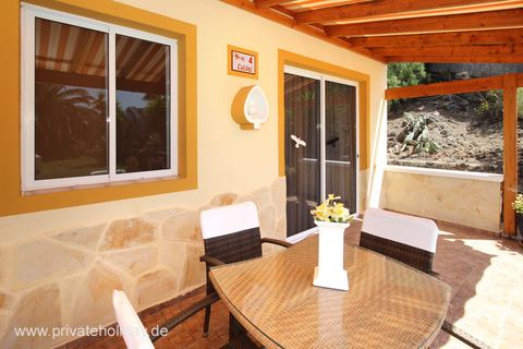 Covered terrace with dining table and garden view – Chio, Tenerife