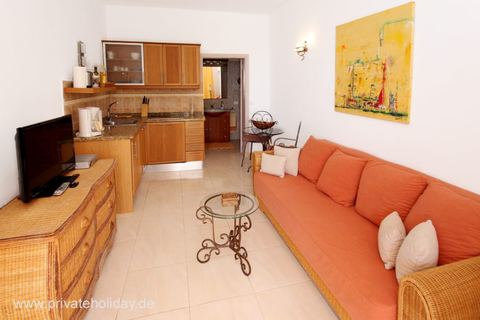Living room with orange sofa and kitchenette – Chio, Tenerife