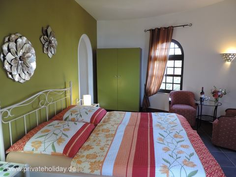 Bedroom with double bed and green accent wall – La Matanza, Tenerife