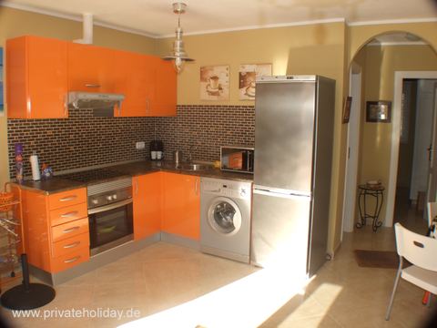 Cocina con armarios naranjas y lavadora – Costa Calma, Fuerteventura
