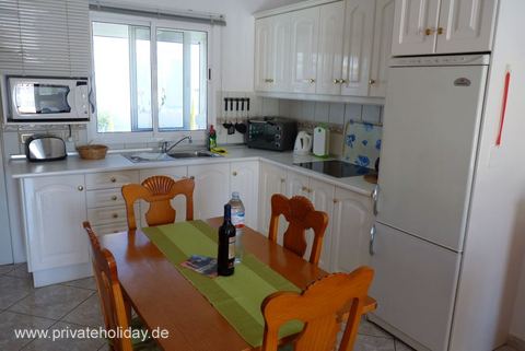 Cocina con mesa de comedor y nevera blanca – Costa Calma, Fuerteventura