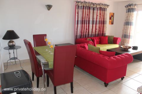 Woonkamer met rode bank en eettafel – Chio, Teneriffa