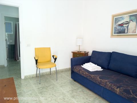 Woonkamer met bank en gele stoel – Los Cristianos, Teneriffa