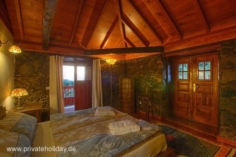 Dormitorio rústico con paredes de piedra y balcón – Tacoronte, Tenerife