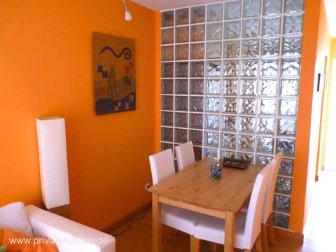Dining area with wooden table and glass block wall – Costa Calma, Fuerteventura