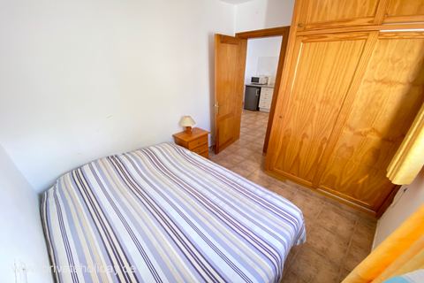 Dormitorio con cama doble y armario de madera – Costa Calma, Fuerteventura