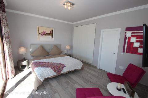 Bright bedroom with double bed and armchair – Guía de Isora, Tenerife