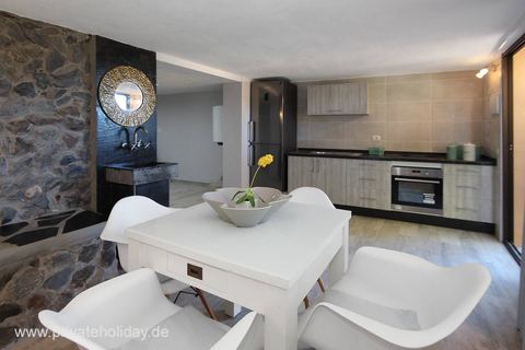 Cocina con mesa de comedor y pared de piedra – Guía de Isora, Tenerife