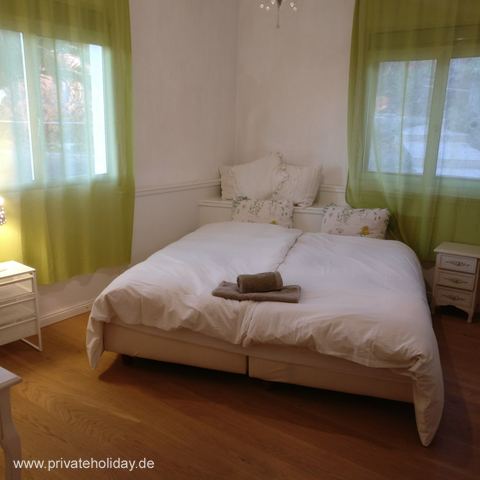 Slaapkamer met tweepersoonsbed en groene gordijnen – Chio, Teneriffa