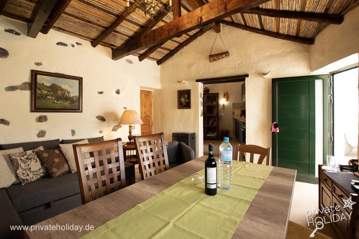 Living room with dining table and wood-beam ceiling – Guía de Isora, Tenerife