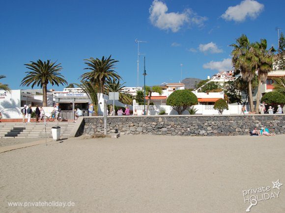 Spiaggia sabbiosa con palme e muretto in pietra – Los Cristianos, Tenerife