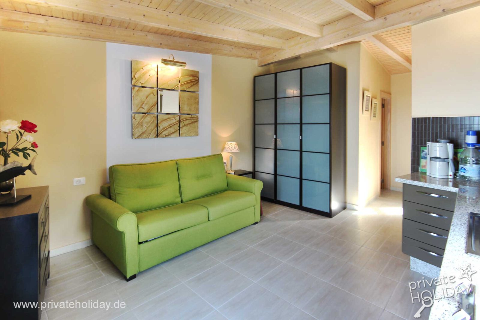 Coin salon avec canapé vert et armoire – Chio, Ténérife