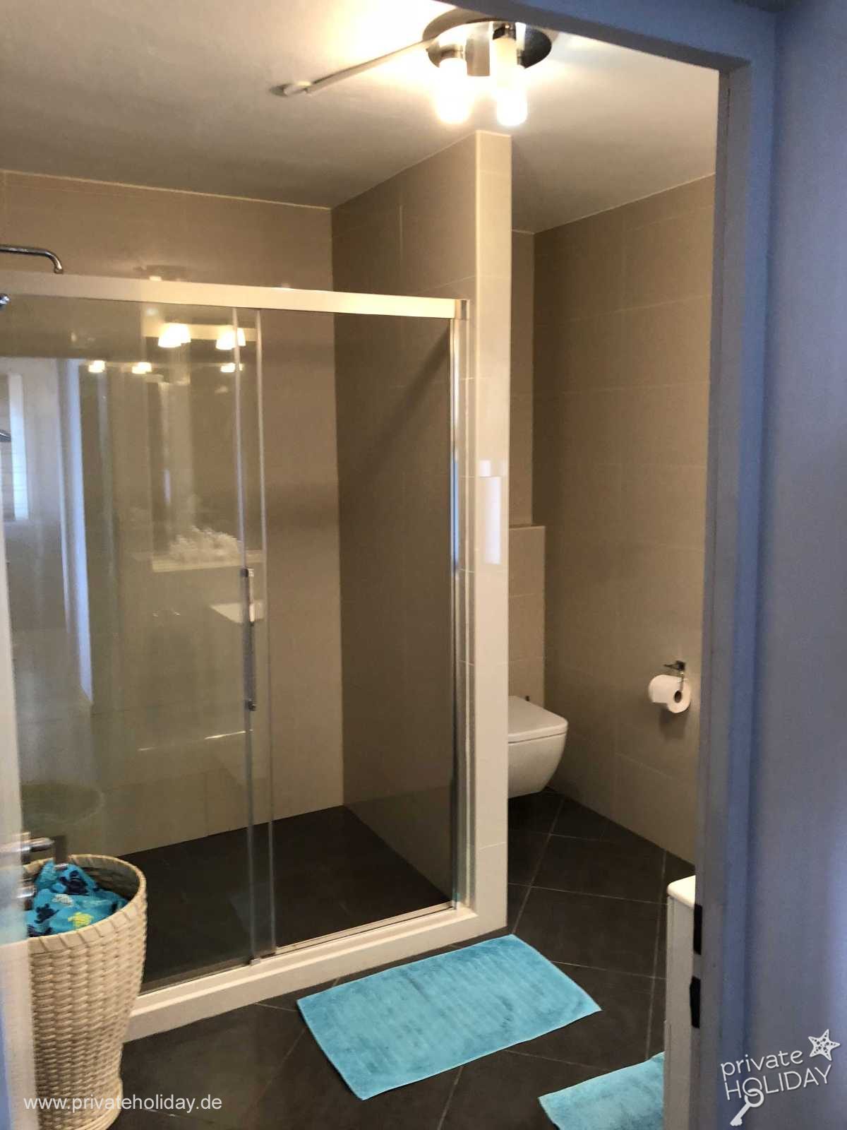 Bathroom with glass shower and light blue mats – Costa Calma, Fuerteventura
