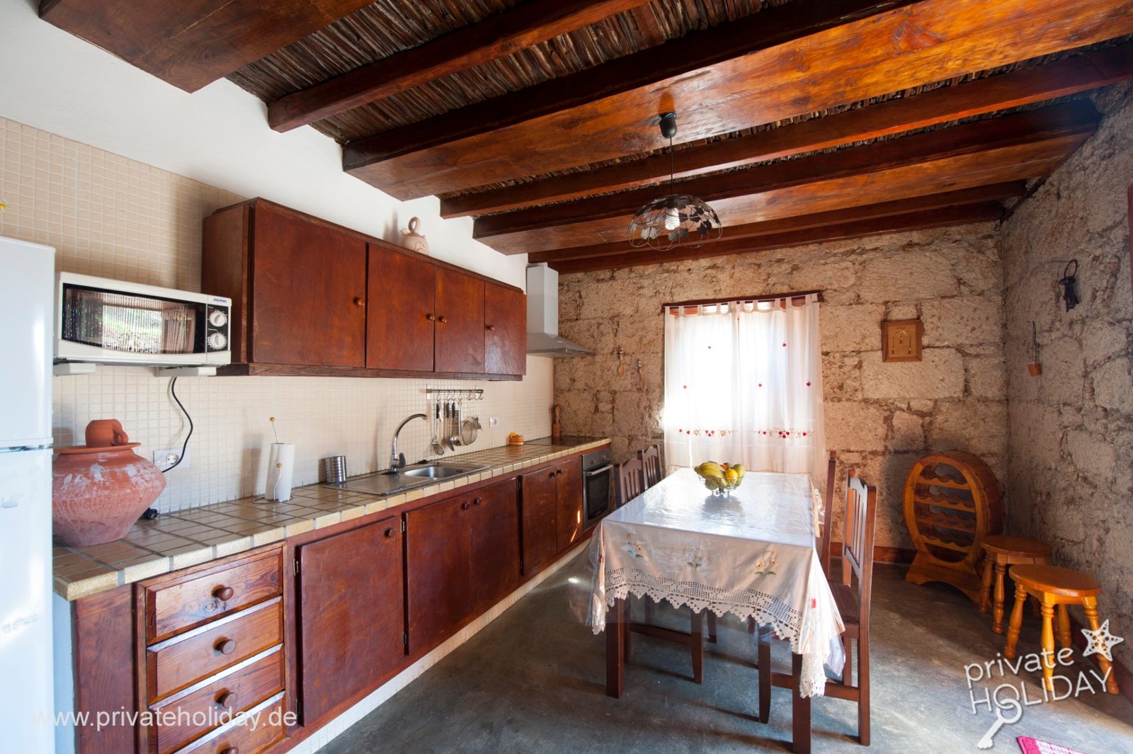 Cocina con mesa de comedor y pared de piedra – Arico, Tenerife