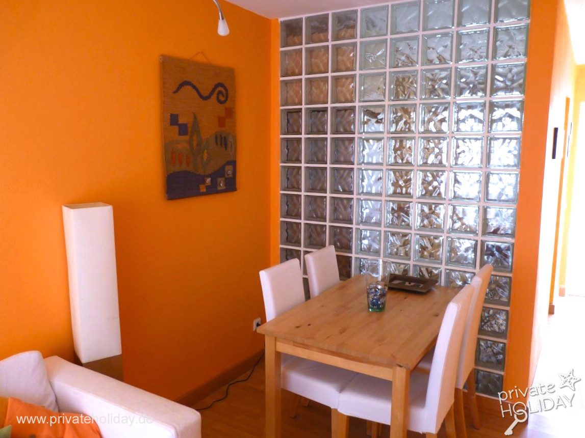 Zona pranzo con tavolo in legno e parete in vetromattoni – Costa Calma, Fuerteventura