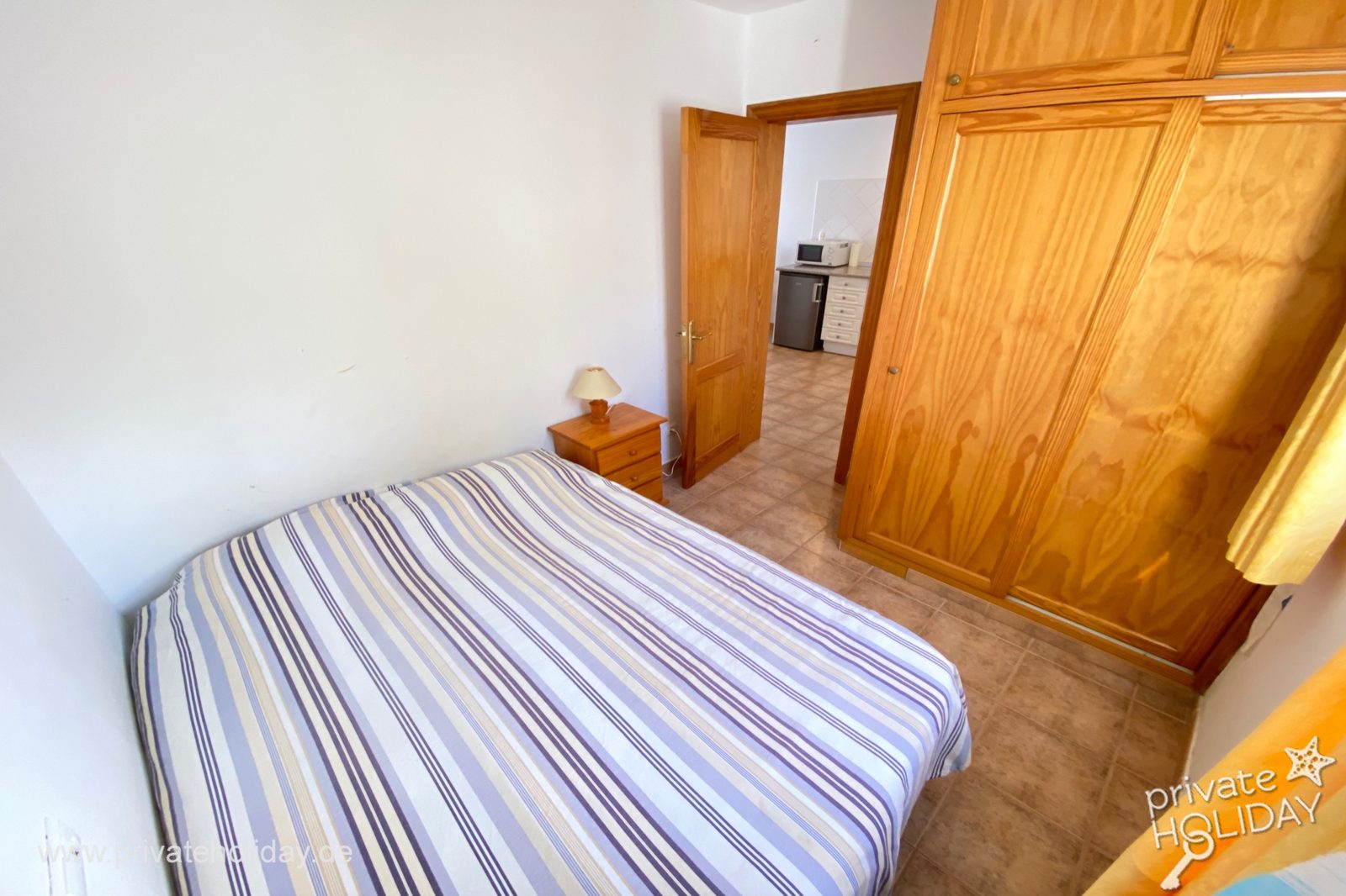 Dormitorio con cama doble y armario de madera – Costa Calma, Fuerteventura