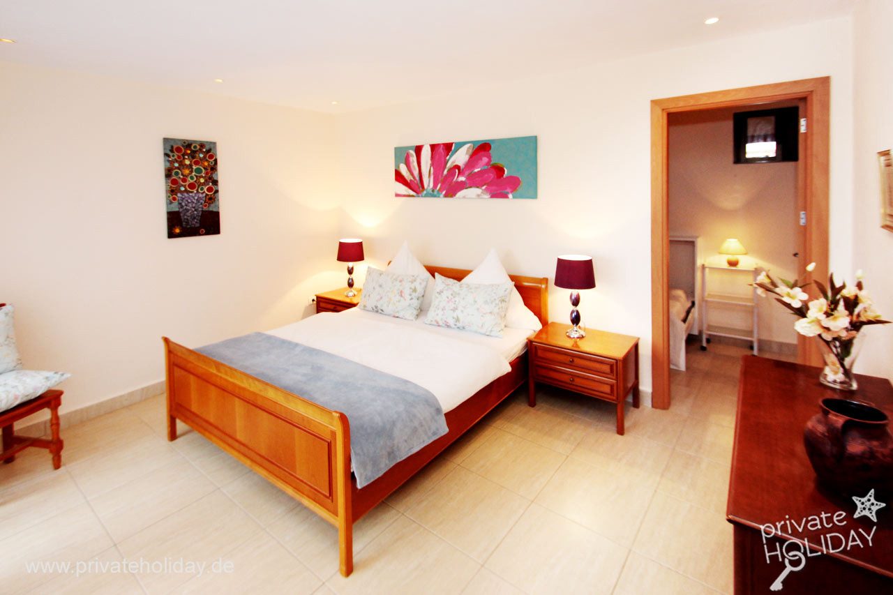Bright bedroom with wooden bed and two bedside tables – Guía de Isora, Tenerife