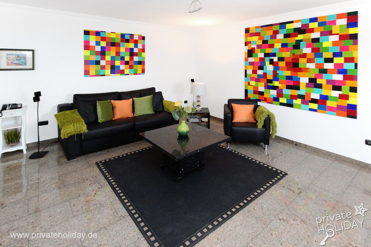 Soggiorno con divano nero e quadri colorati – Alcalá, Tenerife