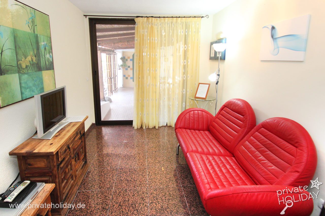 Salón con sofá rojo y puerta corredera – Alcalá, Tenerife