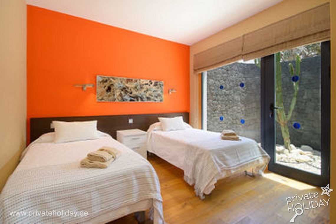 Slaapkamer met twee eenpersoonsbedden en tuindeur – Playa Blanca, Lanzarote