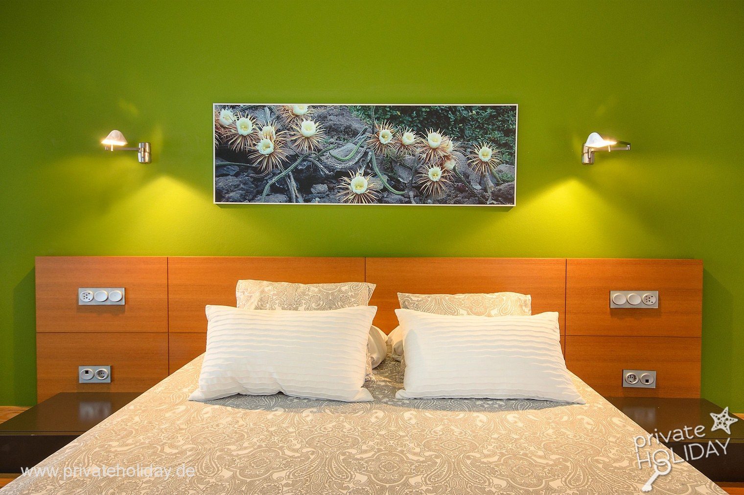 Tweepersoonsbed tegen groene accentmuur – Playa Blanca, Lanzarote
