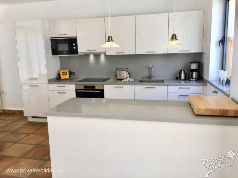 Moderne Küche mit Kochinsel und weißen Schränken – Costa Calma, Fuerteventura